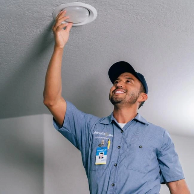 Electrician adjusting light fixture.