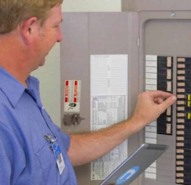 Mr. Electric Tech examining a circuit breaker.