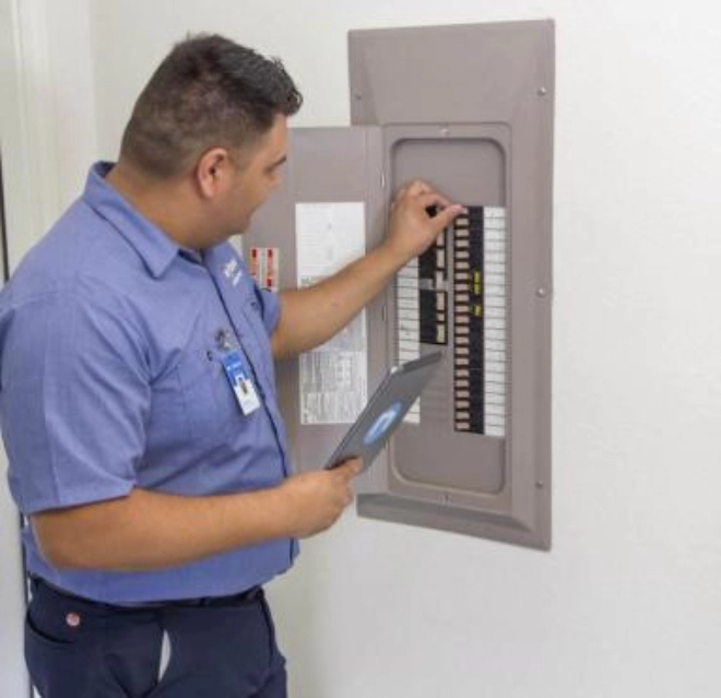 Mr. Electric Technician looking at circuit breaker.