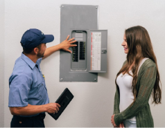 Mr. Electric electrician showing the circuit breaker to the customer.