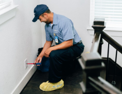 Male Mr. Electric technician inspecting standard electrical outlet.