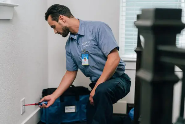 Mr. Electric electrician installing a power outlet .