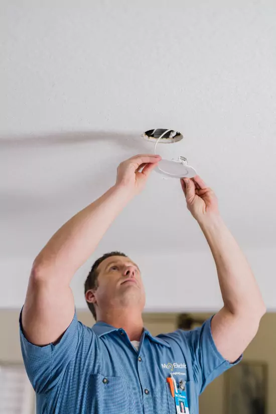 Mr. Electric electrician repairing a flush mount ceiling light.