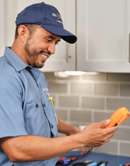 A Mr. Electric electrician testing a GFCI outlet.