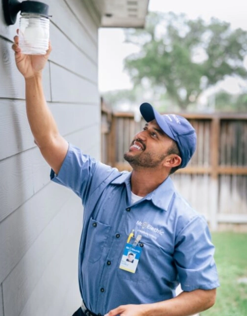 Mr. Electric technician working on an outdoor light fixture.