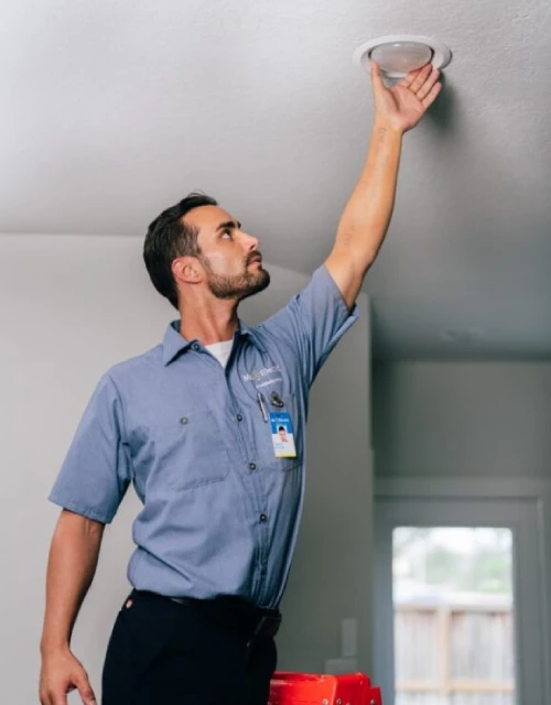 Electrician adjusting lightbulb.