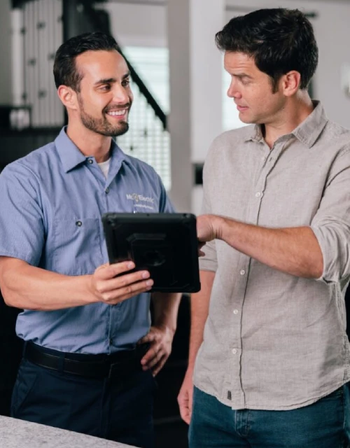 Electrician showing customer information on a tablet.