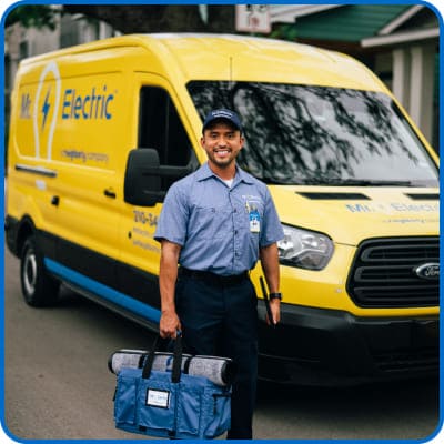 Electrician standing in front of Mr. Electric van.