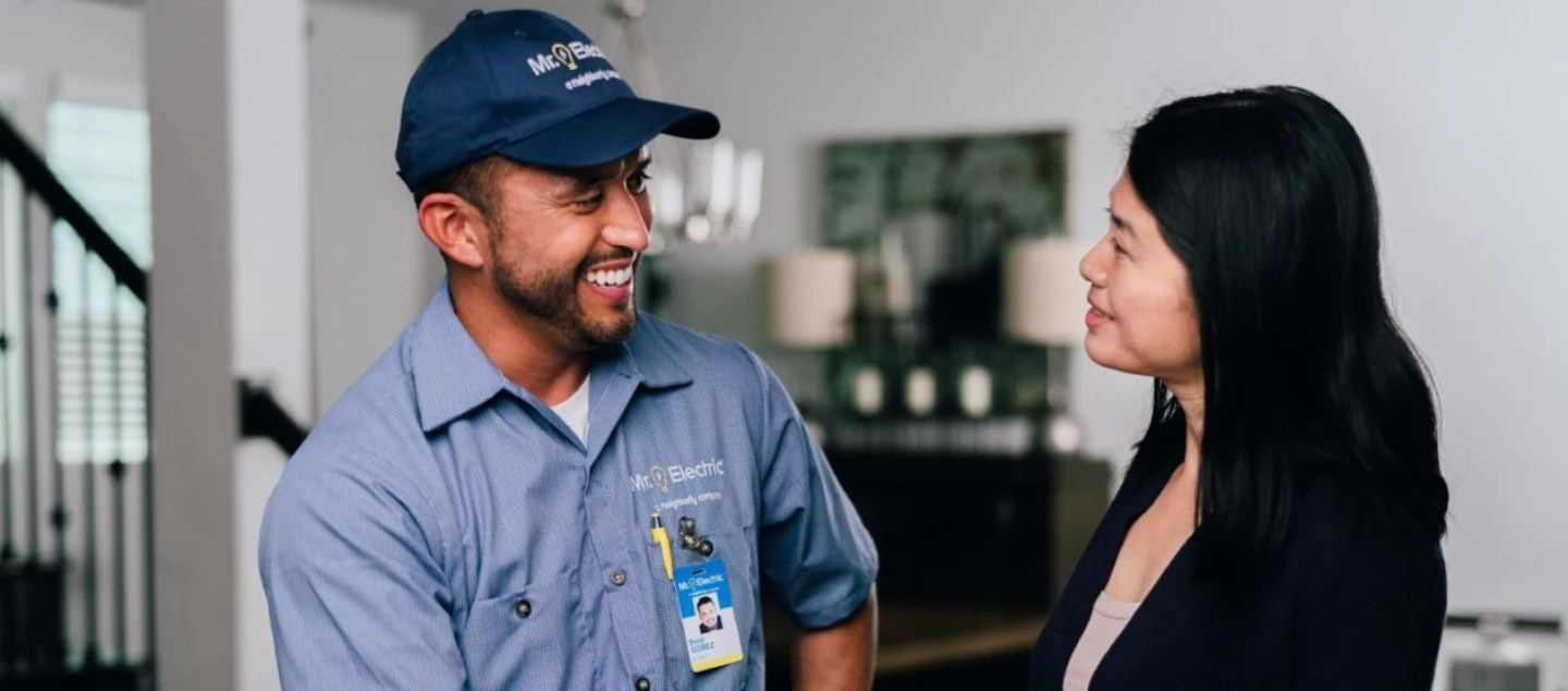 Mr. Electric technician speaking with a female customer.