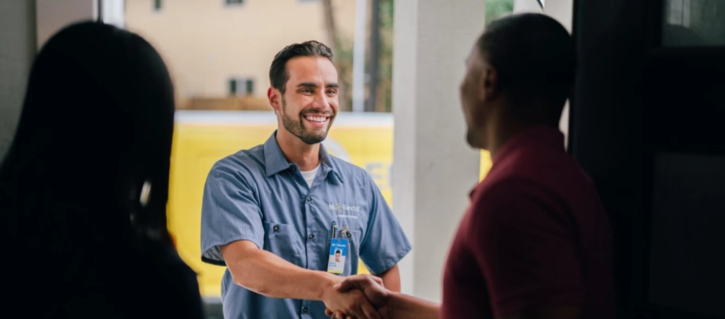 Electrician greeting customers at front door.