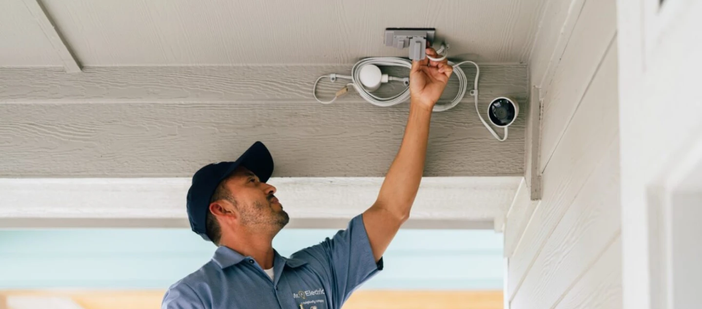 Mr. Electric technician working on a security camera.