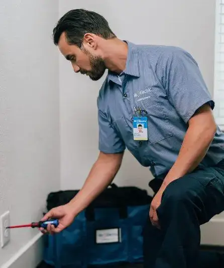 Mr. Electric electrician working on a power outlet.