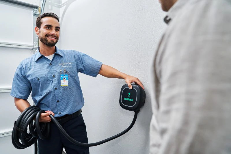 A Mr. Electric electrician performing an EV charger installation.