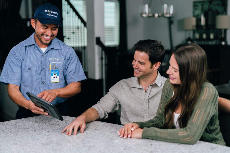 Mr. Electric electrician showing customers a tablet