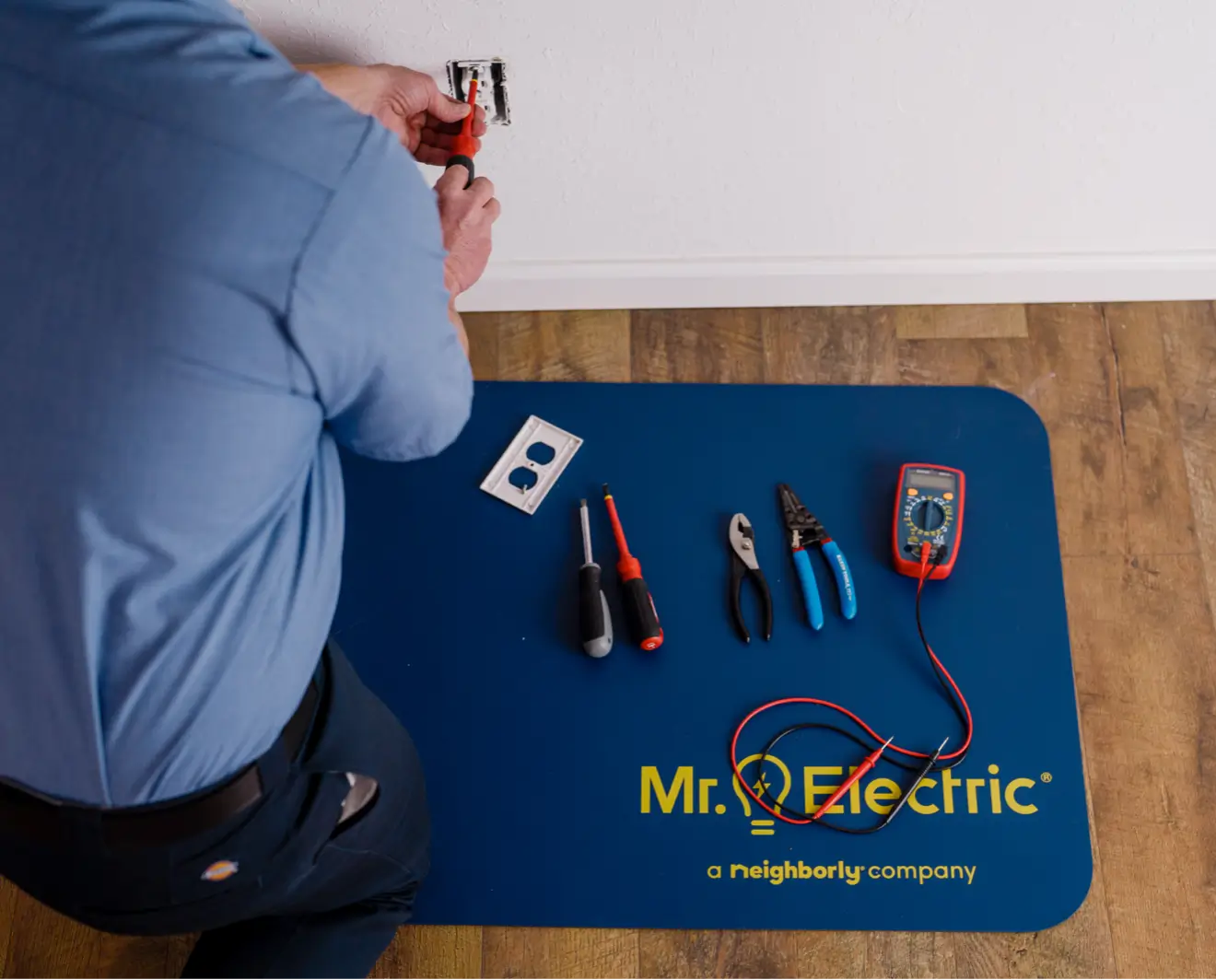 Electrician wiring a 240v outlet with tools on floor