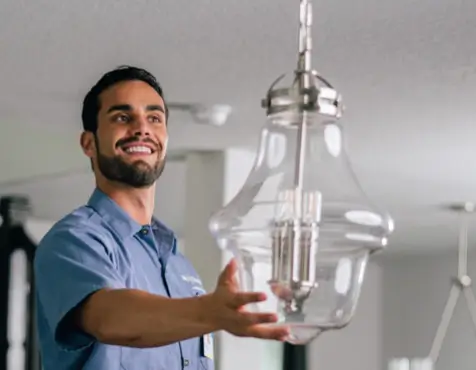 Mr. Electric technician installing a chandelier.