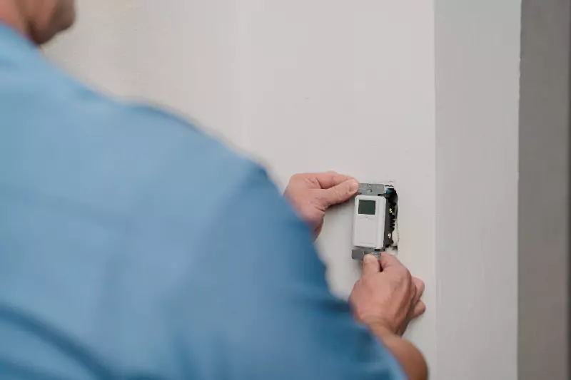 A Mr. Electric electrician installing a light timer switch