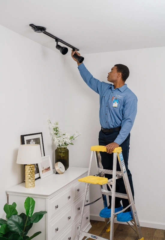 A Mr. Electric electrician installing track lighting in a home 