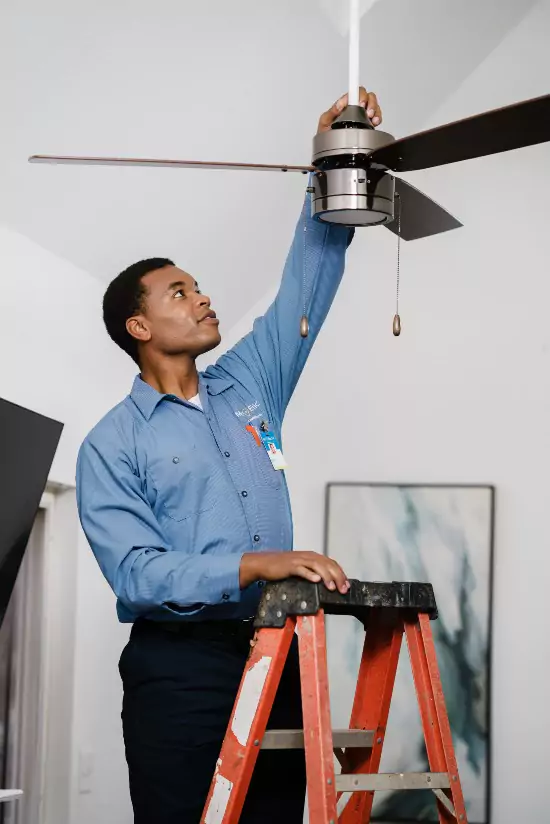 A Mr. Electric electrician performing a ceiling fan installation.