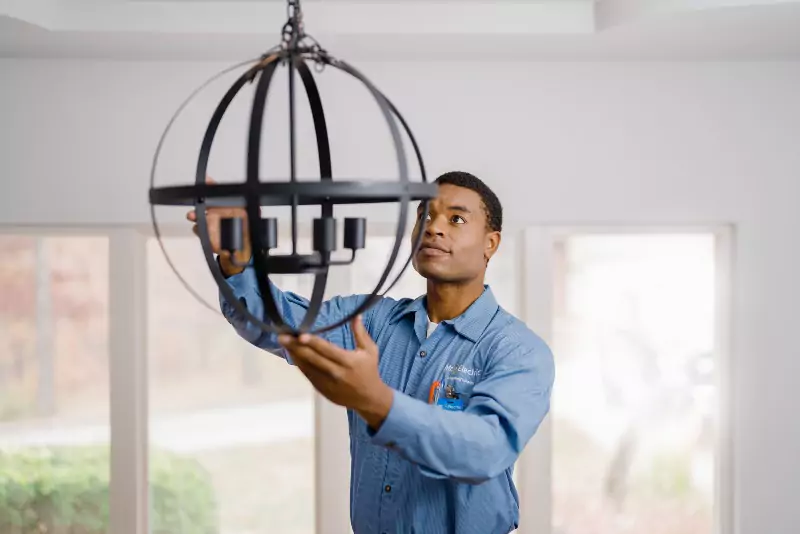 Mr. Electric electrician installing a chandelier