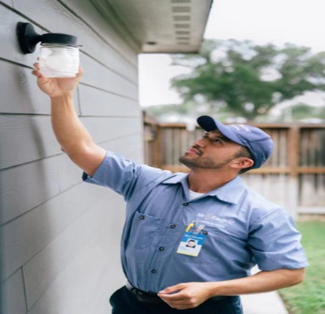 Mre electrician installing an outdoor light.