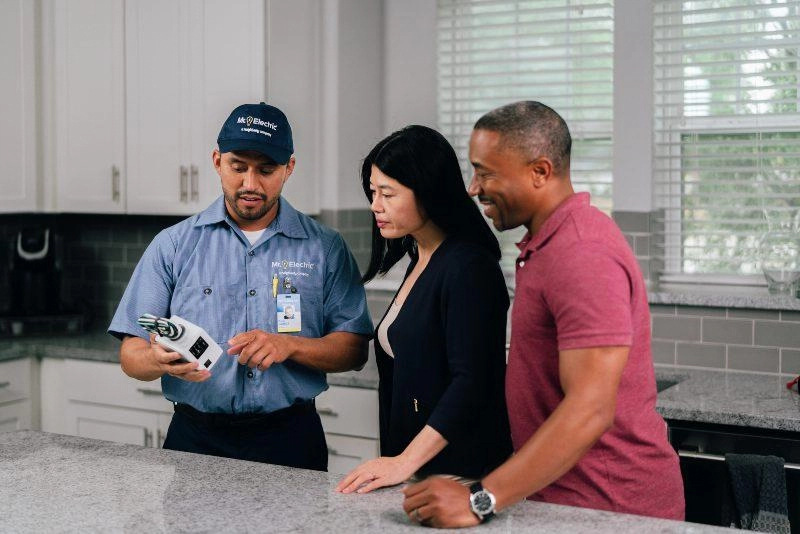 Mr. Electric electrician explaining electrical code updates to a couple