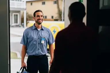 A man in shadow talking to a technician.