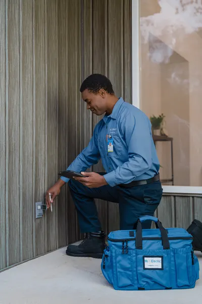 An electrician performs outlet repairs