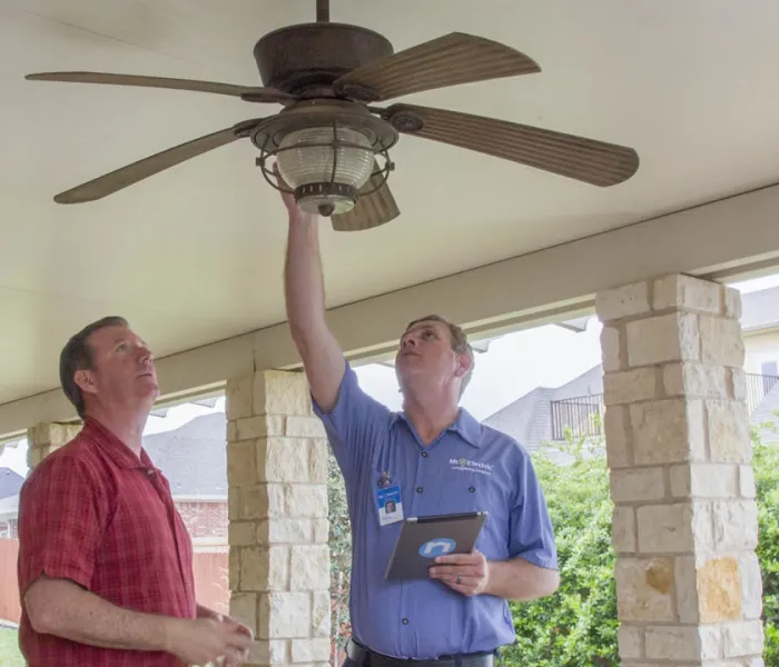 An mre employee inspecting a ceiling fan.