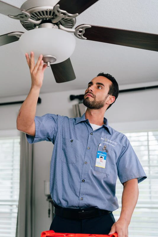 Mr. Electric electrician working on a ceiling fan light.