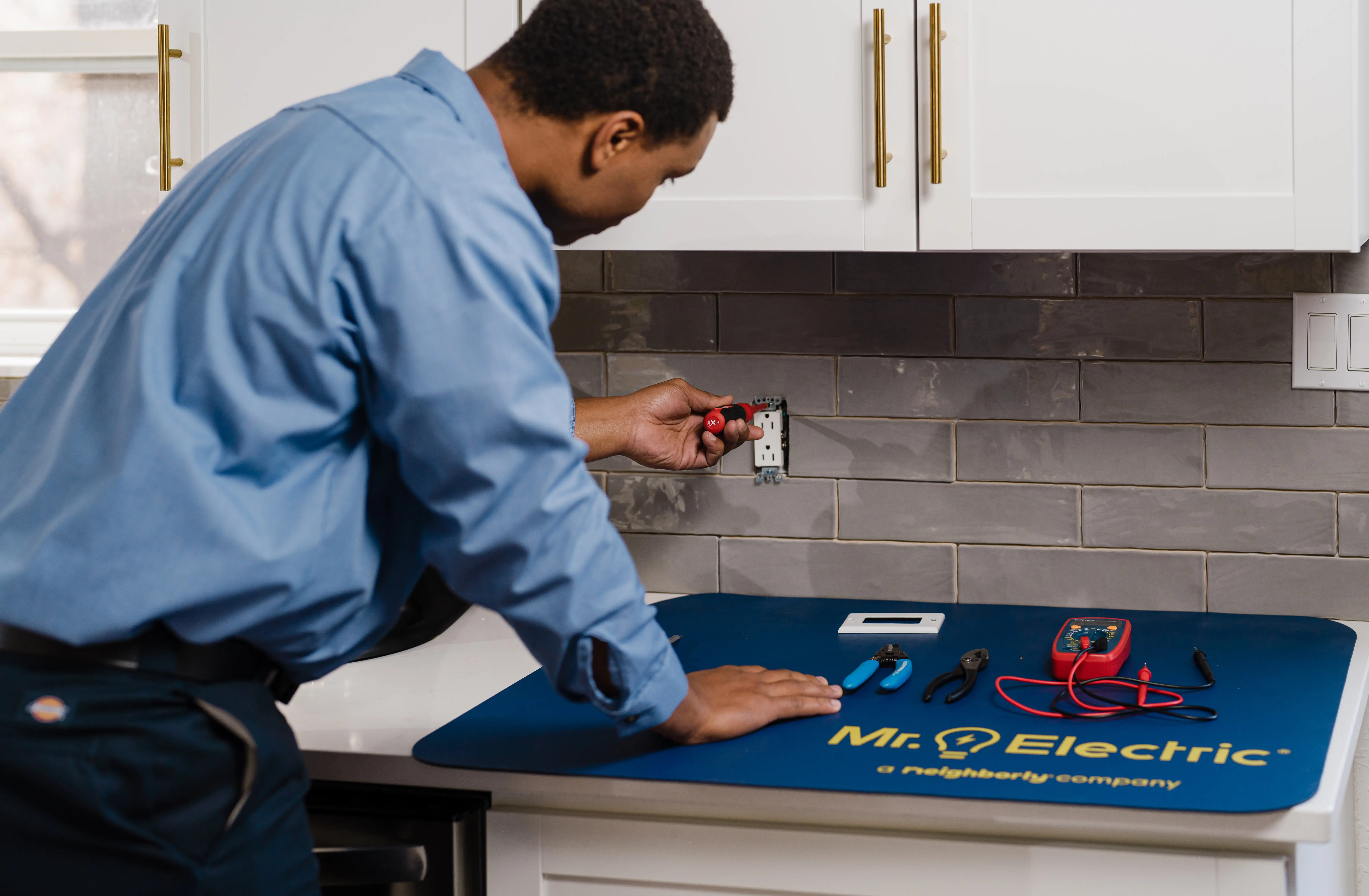 Mr. Electric electrician installing an electrical outlet 