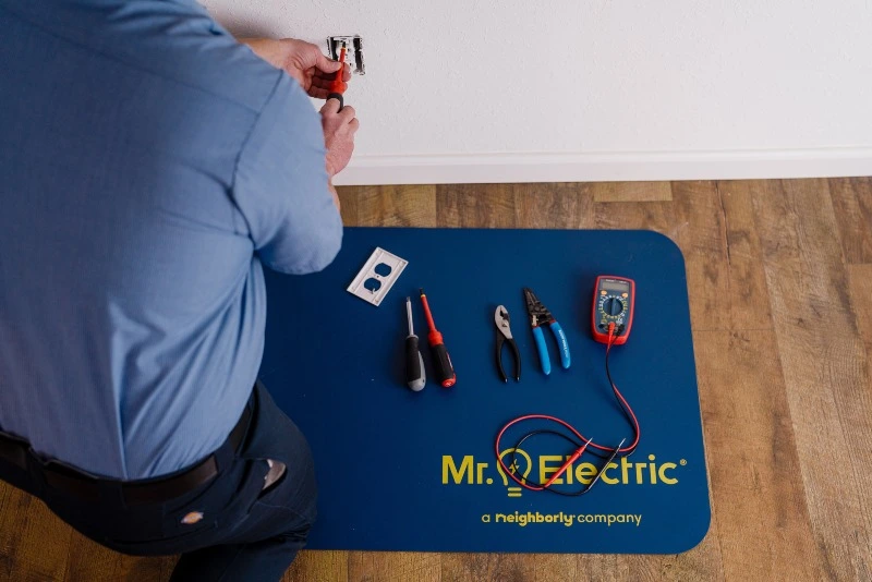 Mr. Electric electrician repairing an electrical outlet in Bell Aire, KS