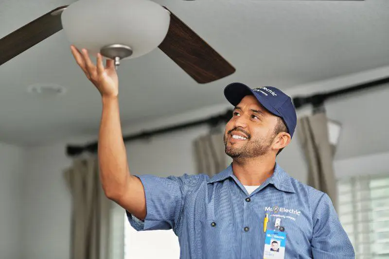 Mr. Electric electrician performing a ceiling fan installation.