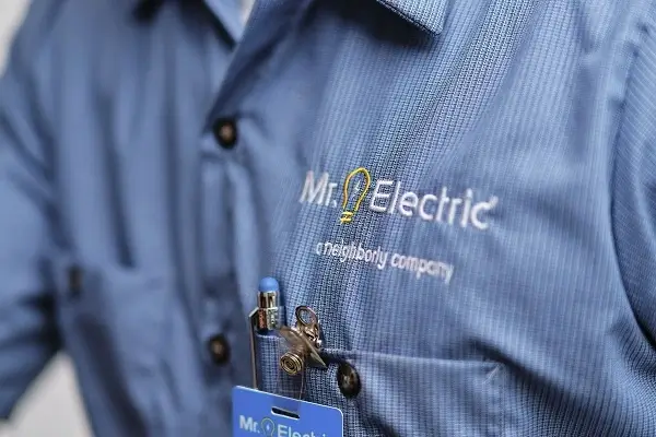 close up of a man’s chest in a blue work shirt with a Mr. Electric logo and a pen in the pocket