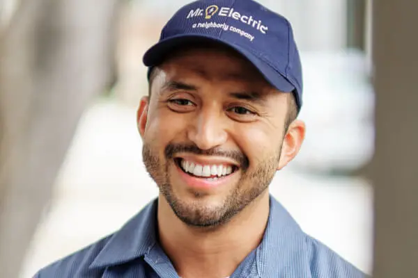 Close-up of the head and shoulders of a smiling Mr. Electric service professional wearing a blue Mr. Electric hat.