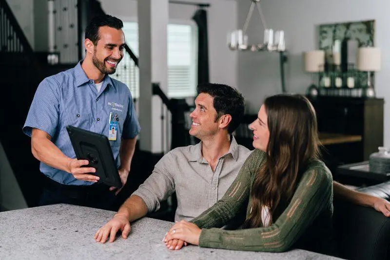 Mr. Electric electrician showing a tablet to a man.