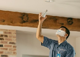 Mr. Electric service professional changing out a lightbulb.