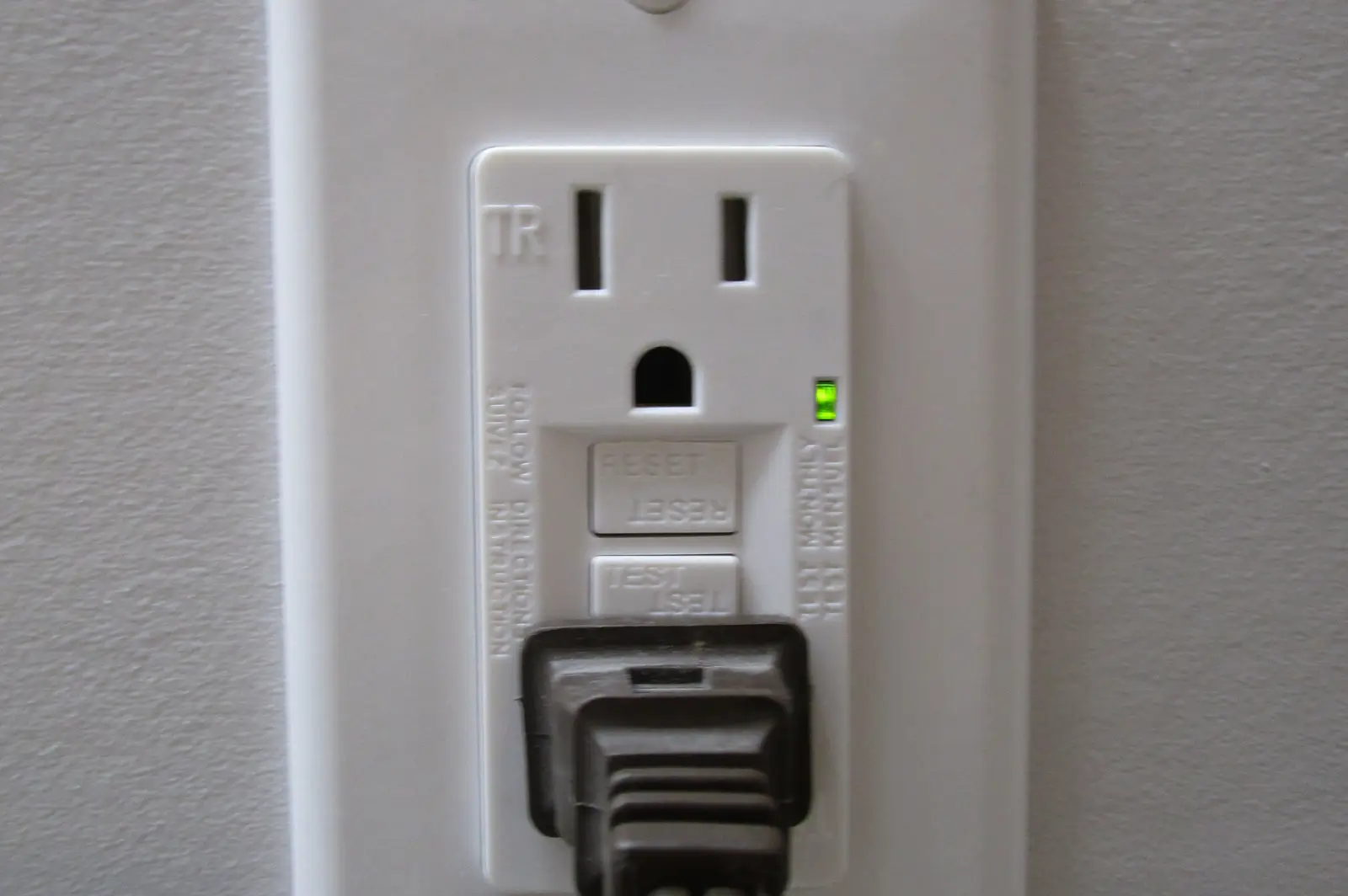 A GFCI outlet with a cord plugged into it