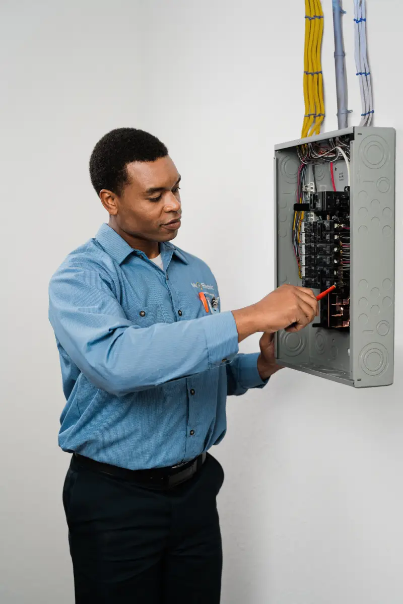 A Mr. Electric service professional inspecting a residential breaker.