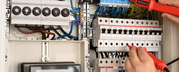 An electrician testing a fuse box.