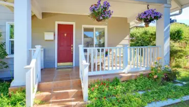 White front porch with red door.