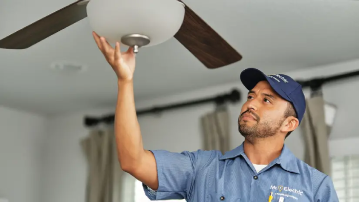 electrician working on a ceiling fan.