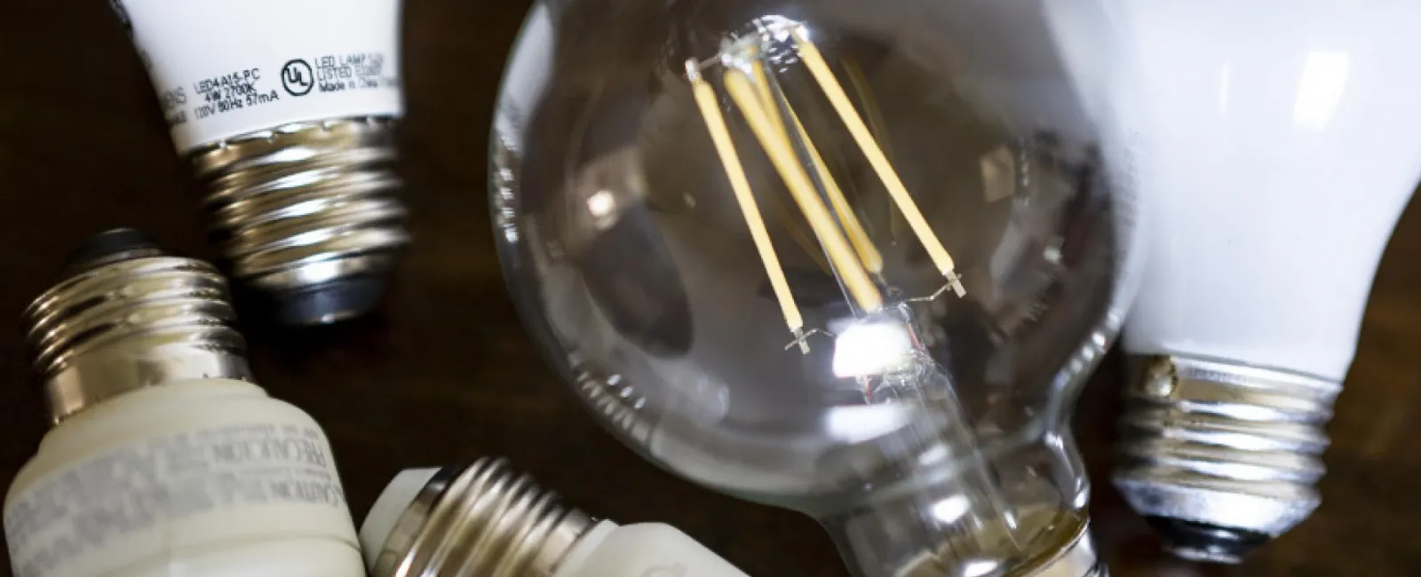 A group of light bulbs on top of a wooden table.