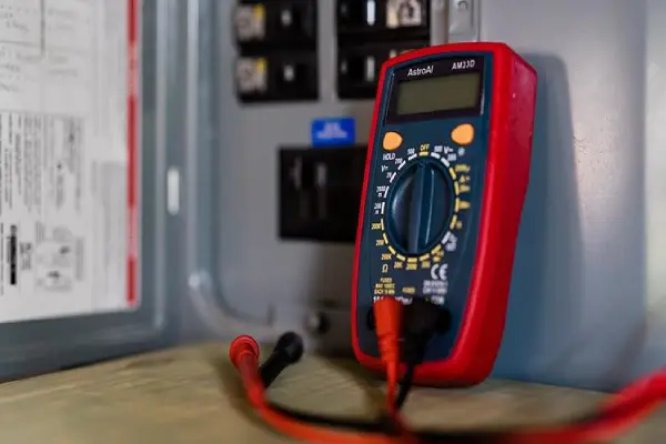 A multimeter on top of a wooden table.