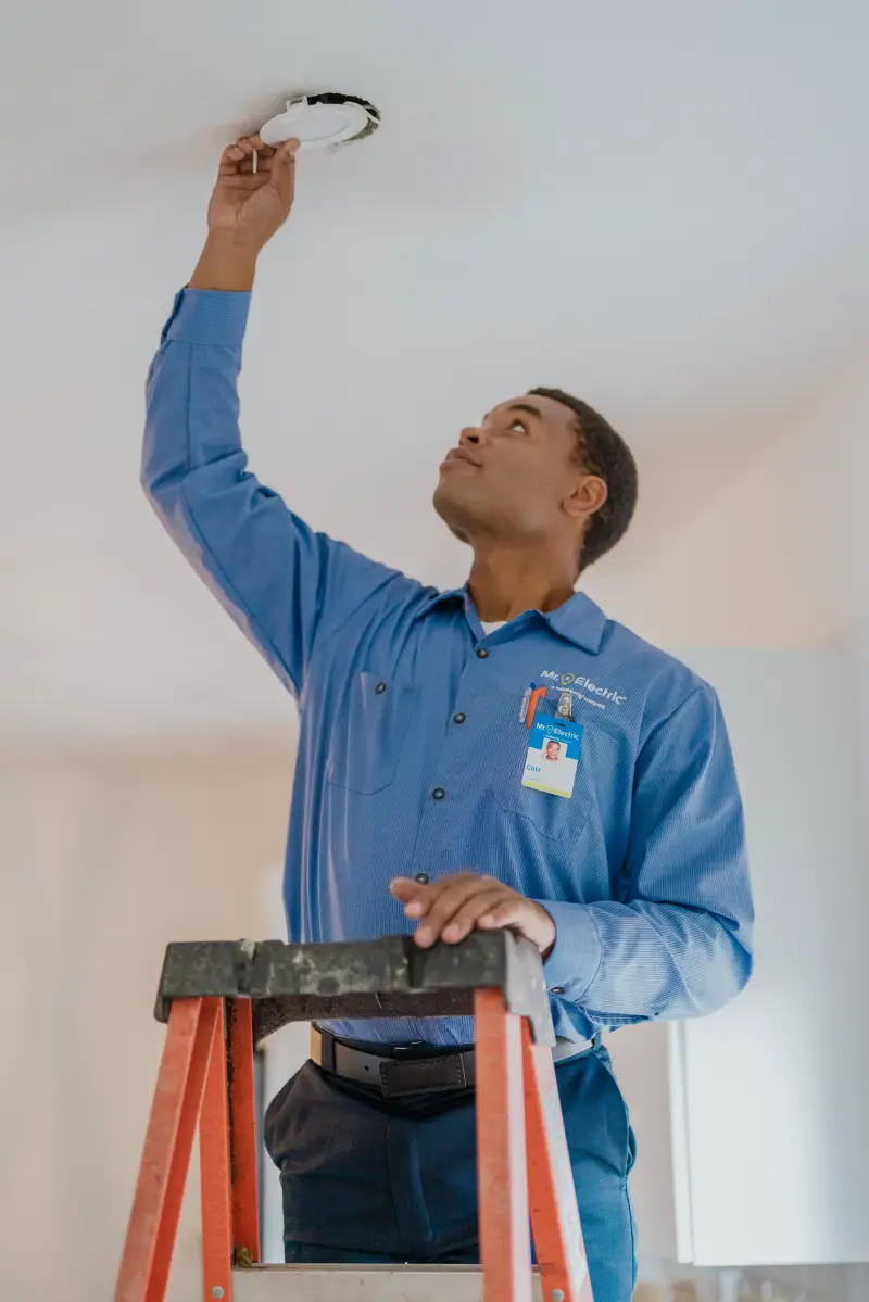 A Mr. Electric service professional securing recessed lighting.