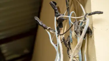 Unsafe wiring wrapped with electrical tape and exposed