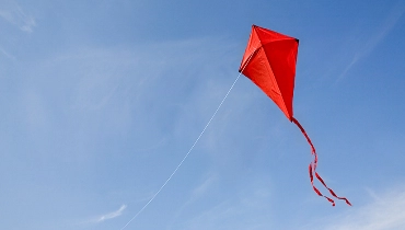 A red kite flying in the sky.