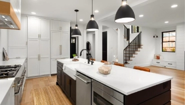 Beautiful white kitchen with dark accents in new modern farmhouse style luxury home