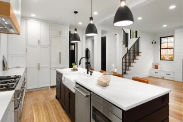 Beautiful white kitchen with dark accents in new modern farmhouse style luxury home.