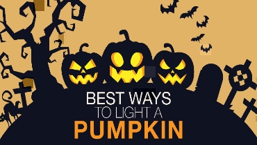 A Halloween picture with three pumpkins with evil faces carved and dark trees, bats, and graveyard crosses on a hill.